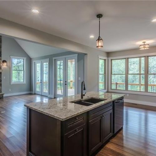 A bright kitchen showcasing a large island and rich hardwood floors